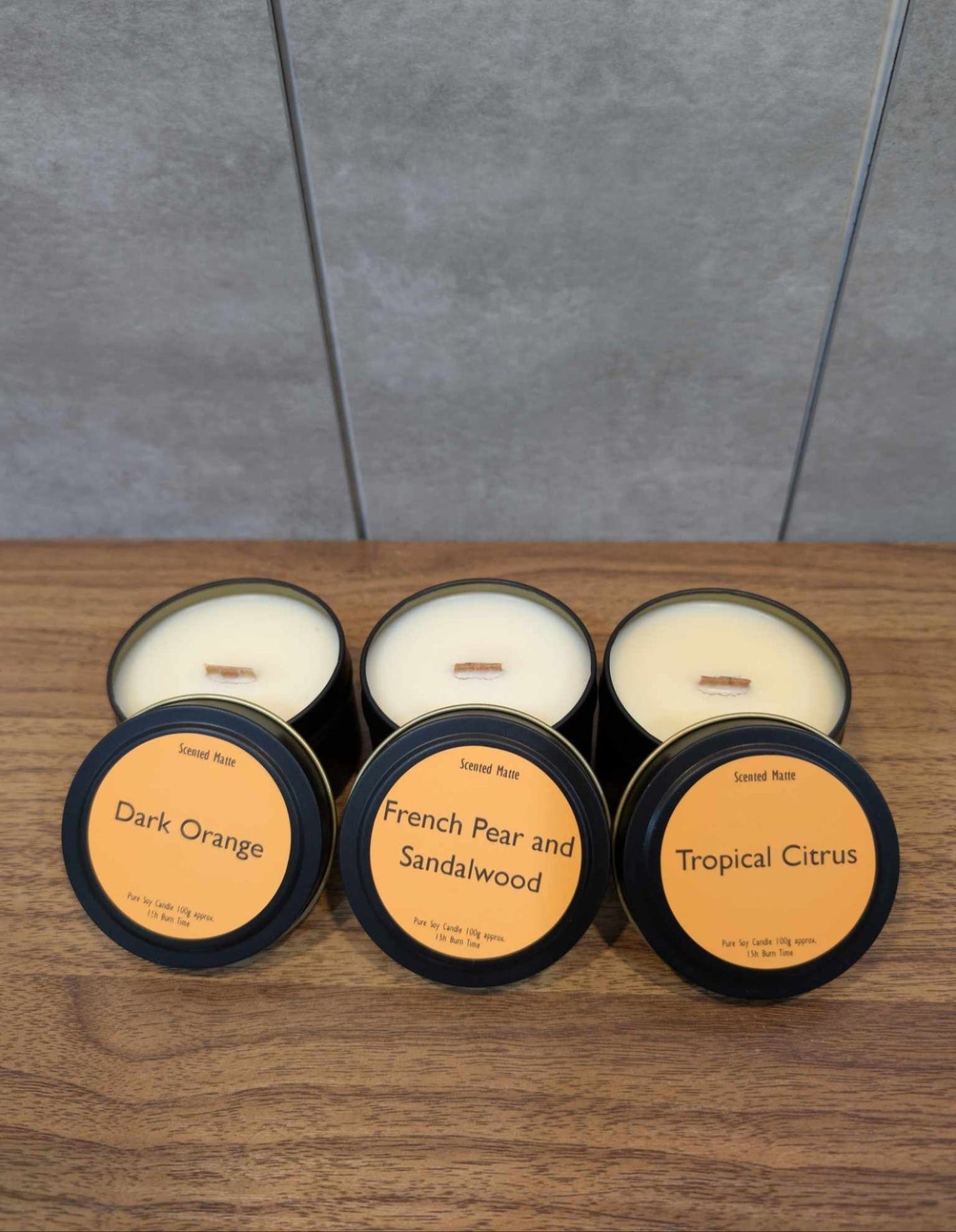 3 soy wooden wick candle tins with lids showing labels
