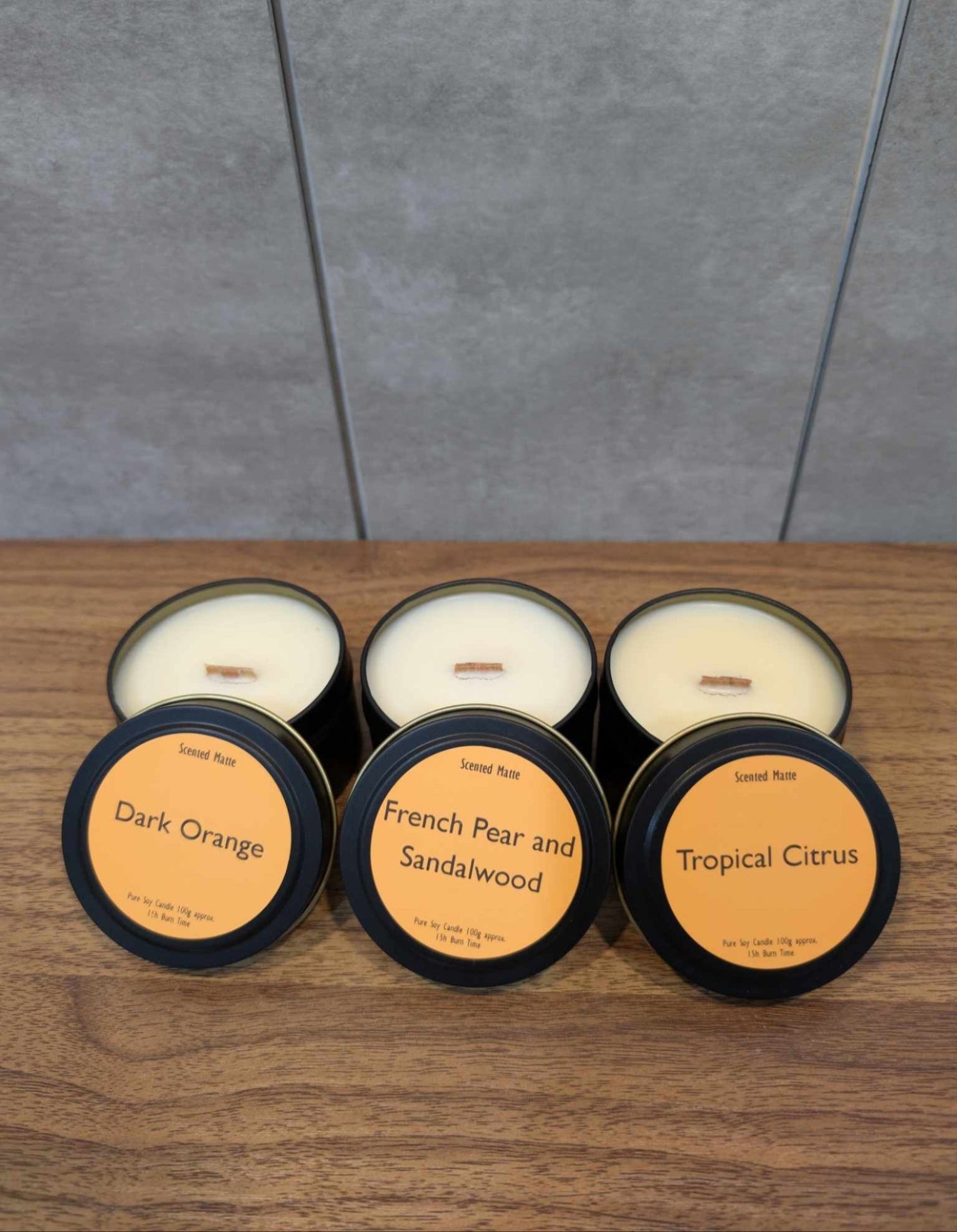 3 soy wooden wick candle tins with lids showing labels